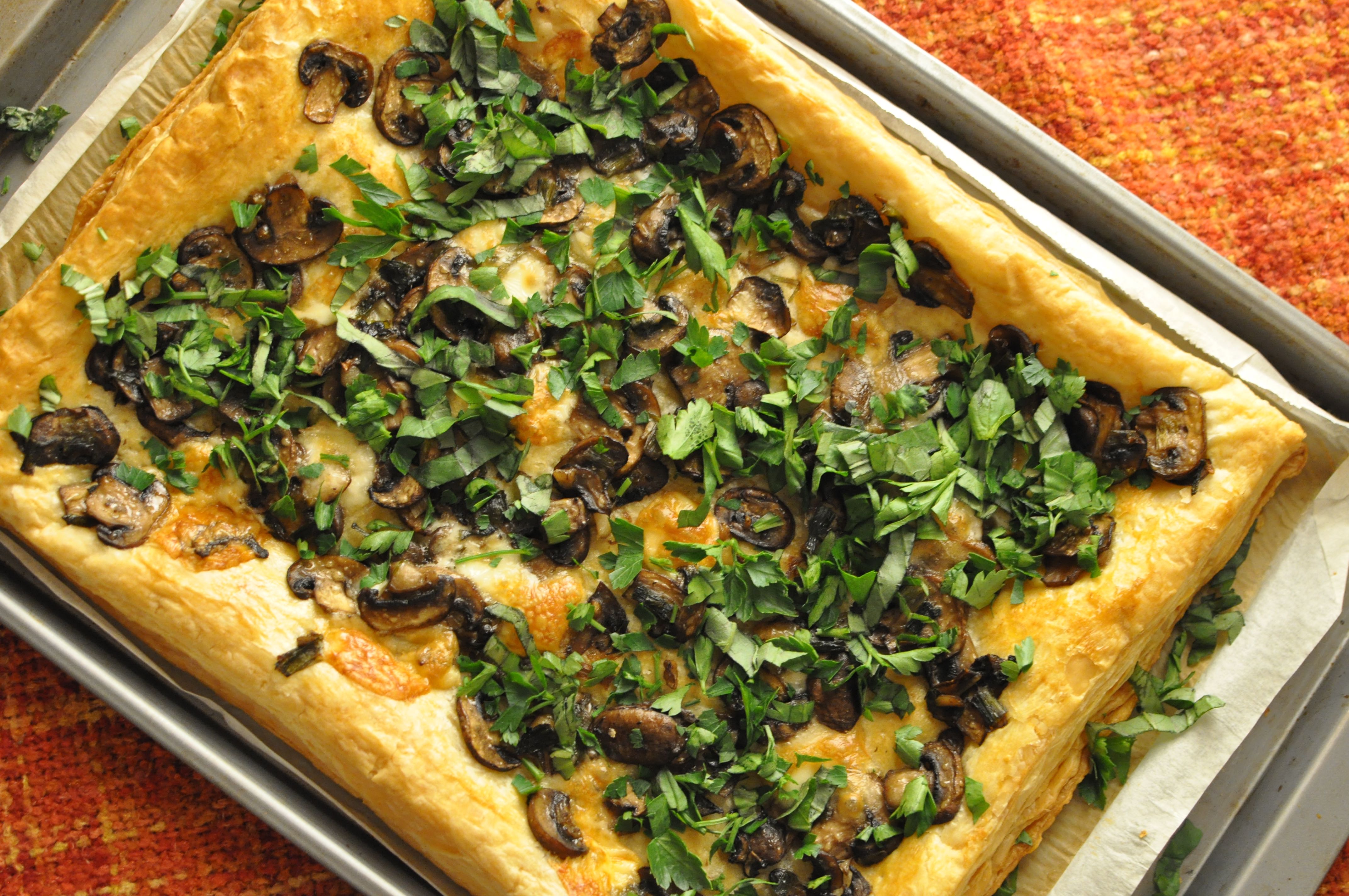 tray of mushroom and taleggio puff pastry on an orange back drop