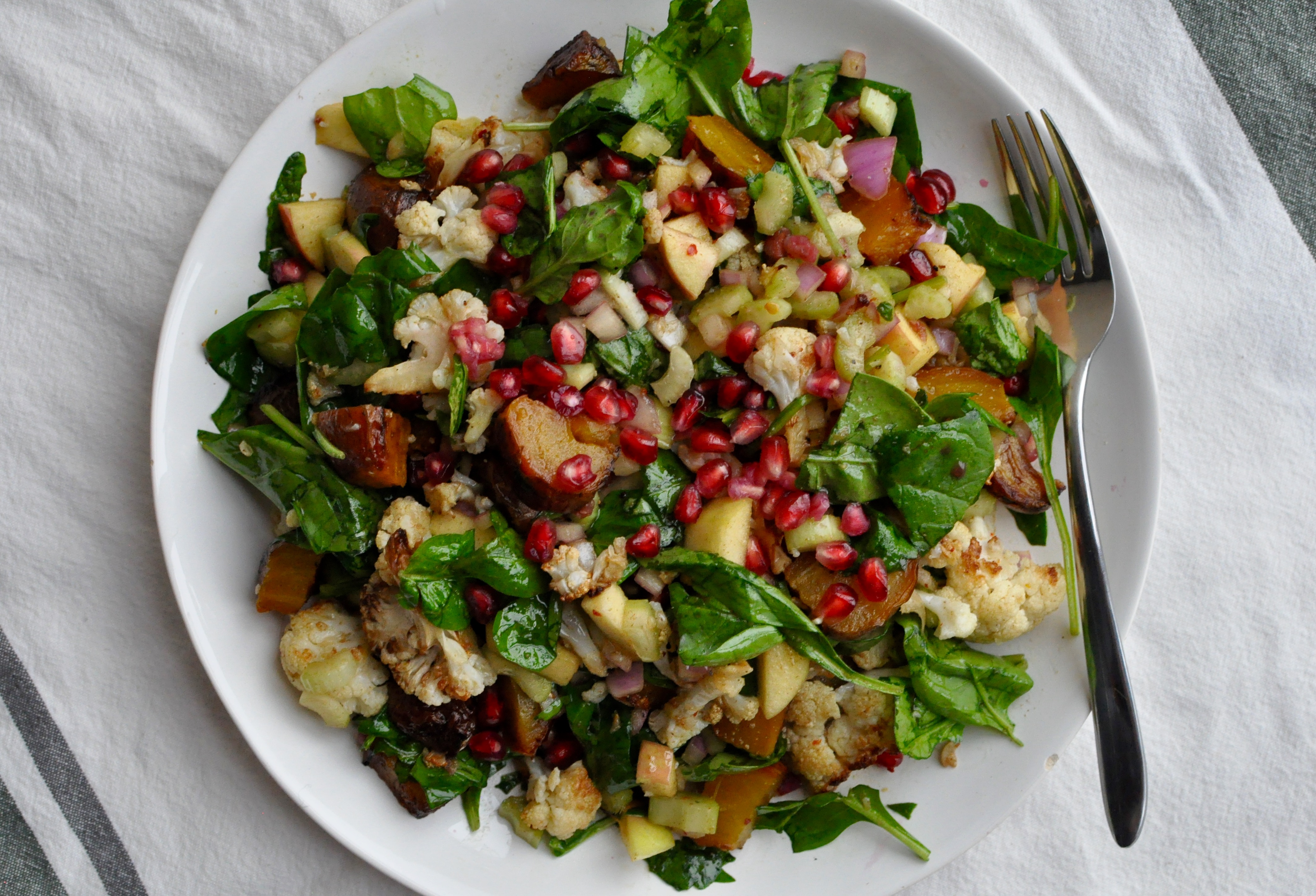 Plate full of salad with roasted cauliflower and golden beets.