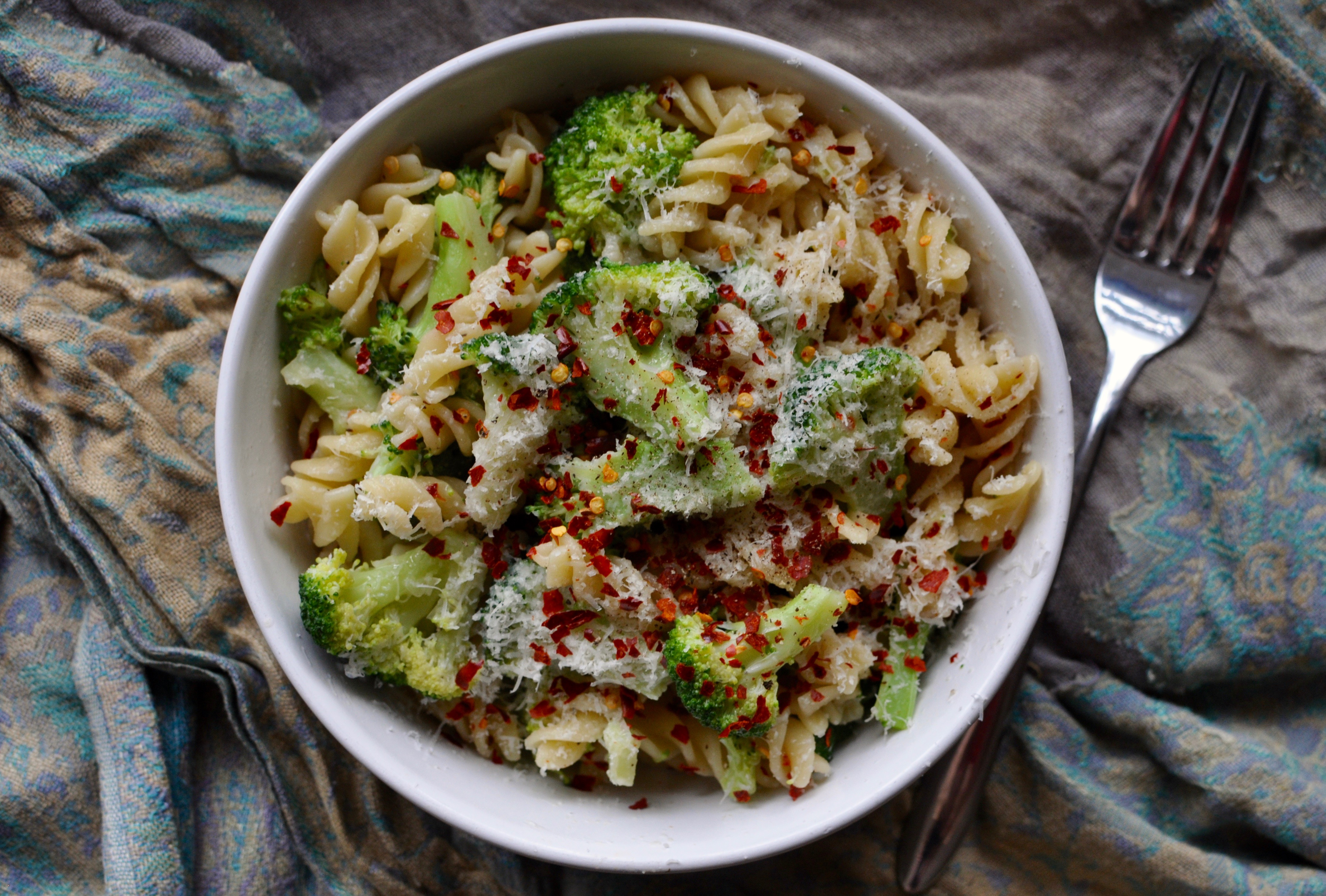 Bowl of rotini pasta with broccoli, chillies, and parmesan.