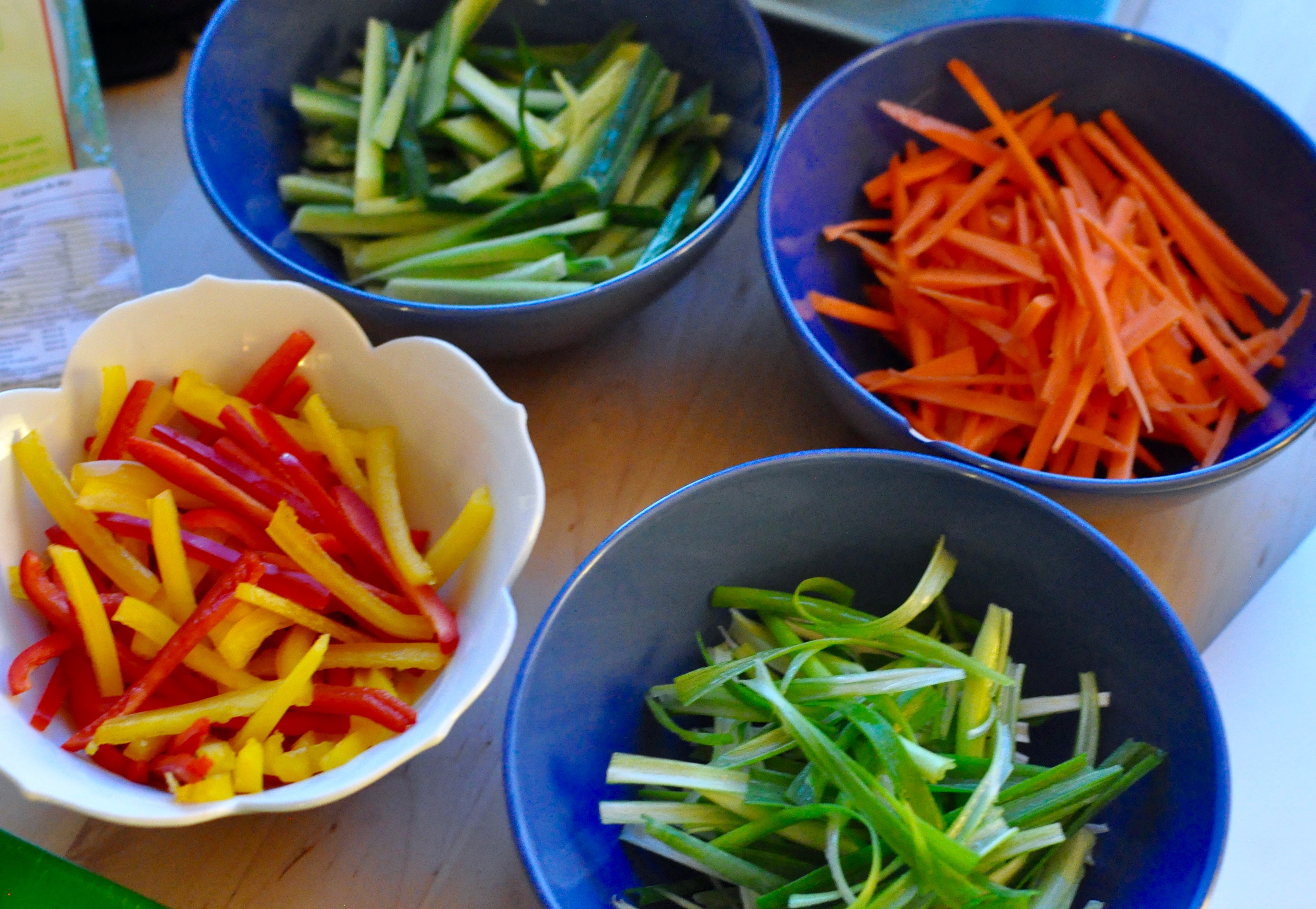 Cut up vegetables for salad rolls on bowls