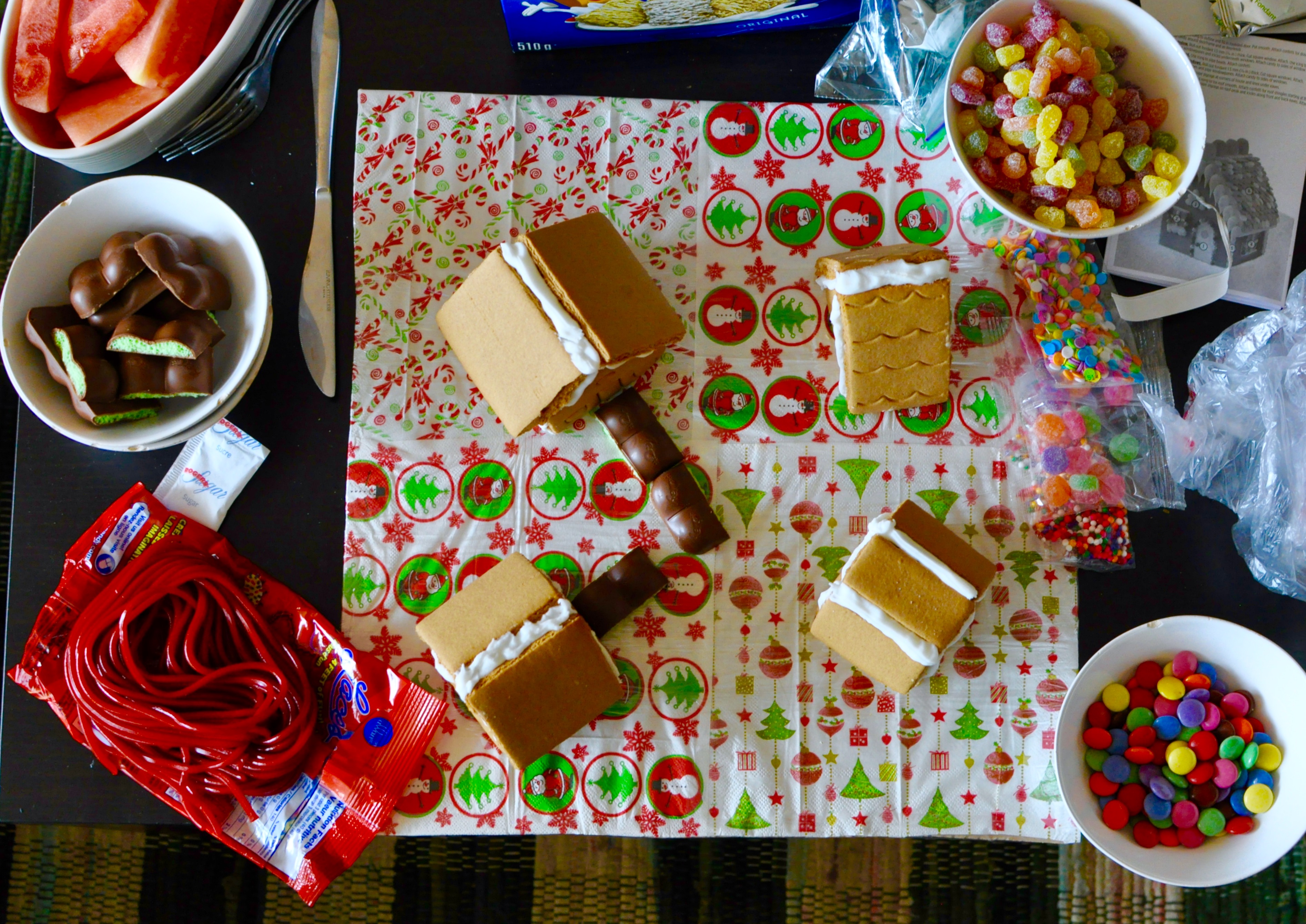 Gingerbread house making supplies on a table from above.
