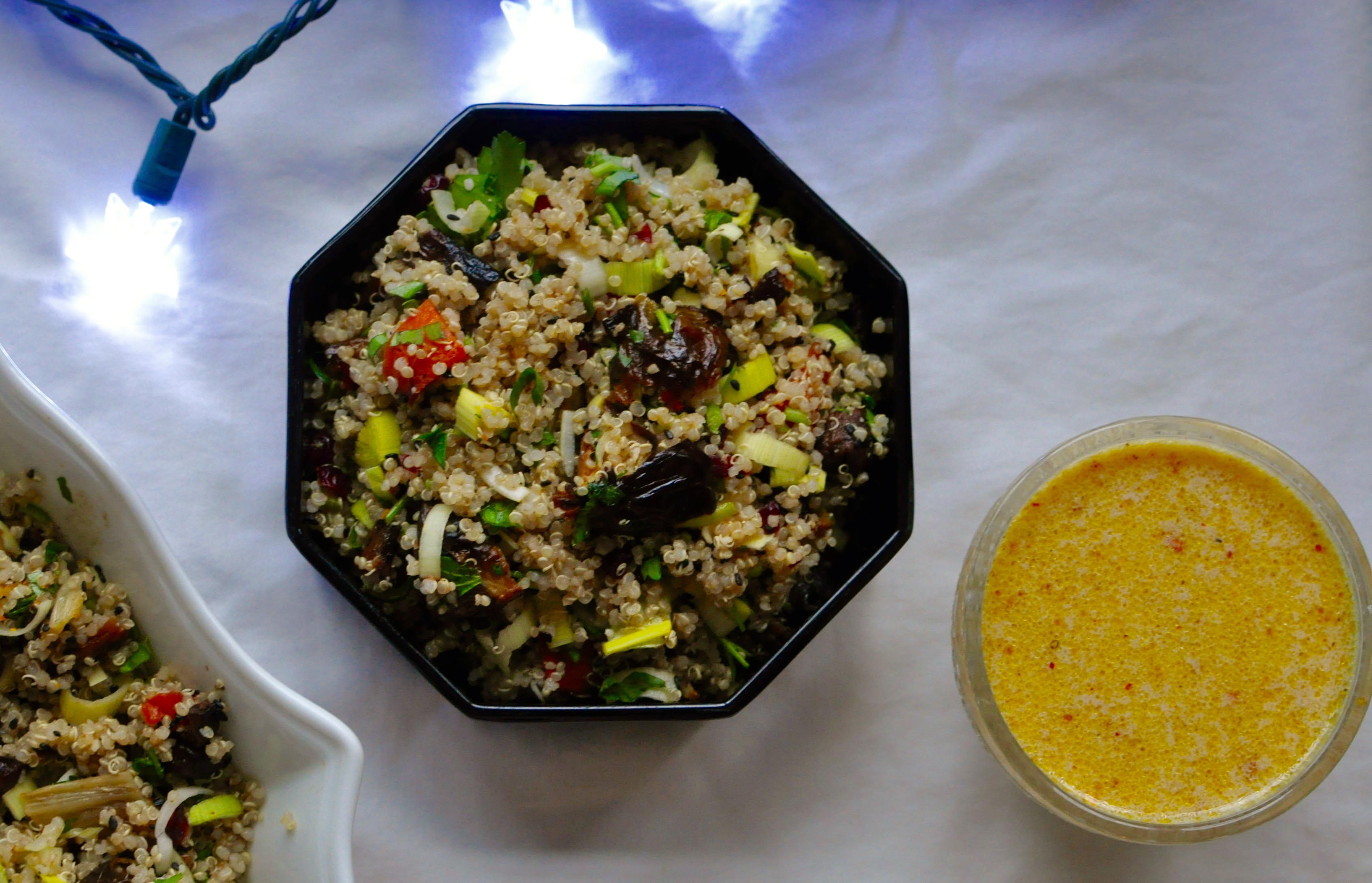 Hexagonal dish of quinoa salad with Christmas lights off to the side.