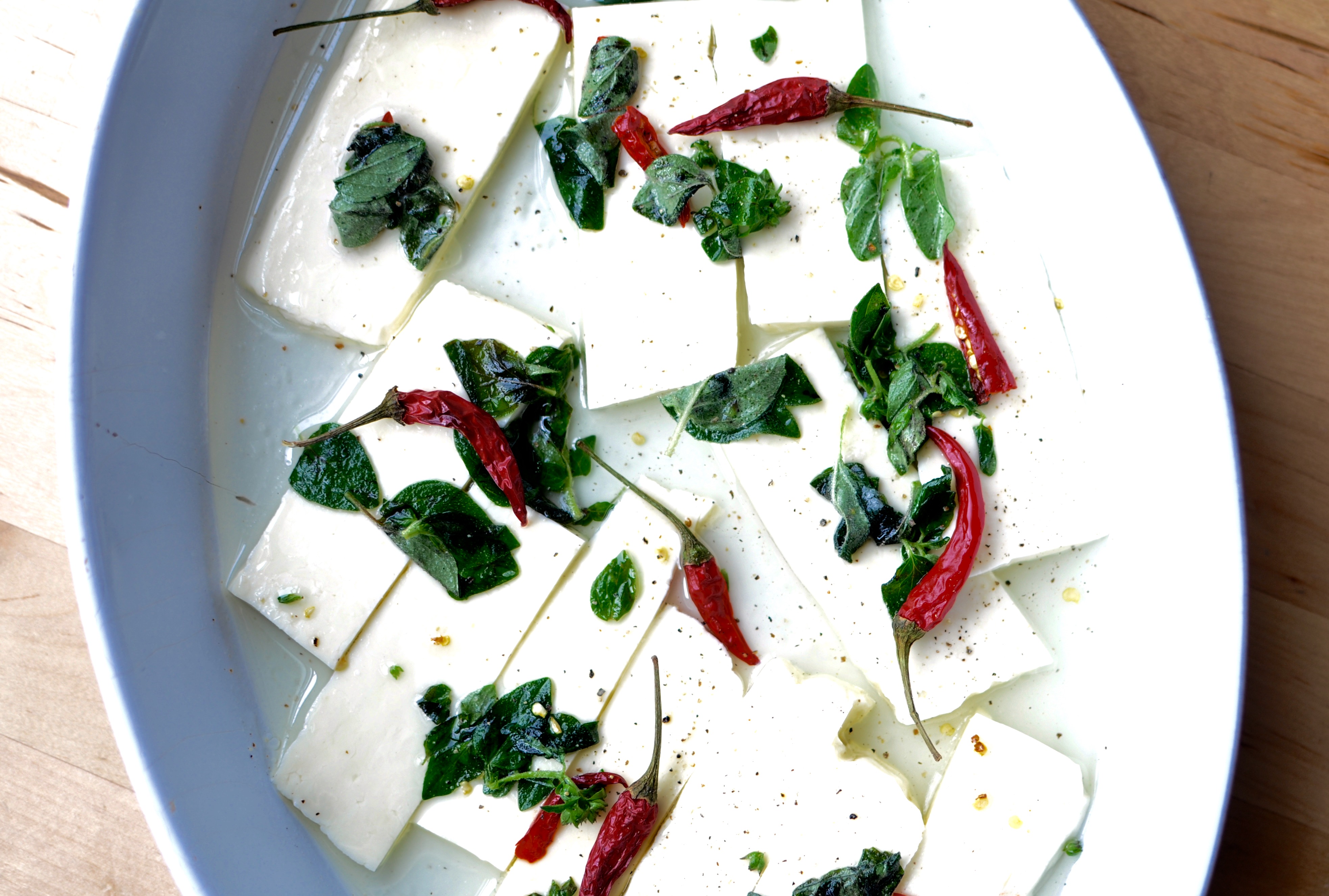 Sliced Halloumi Marinating in Lemon Juice, Olive Oil, Bird's Eye Chilies, and Fresh Oregano